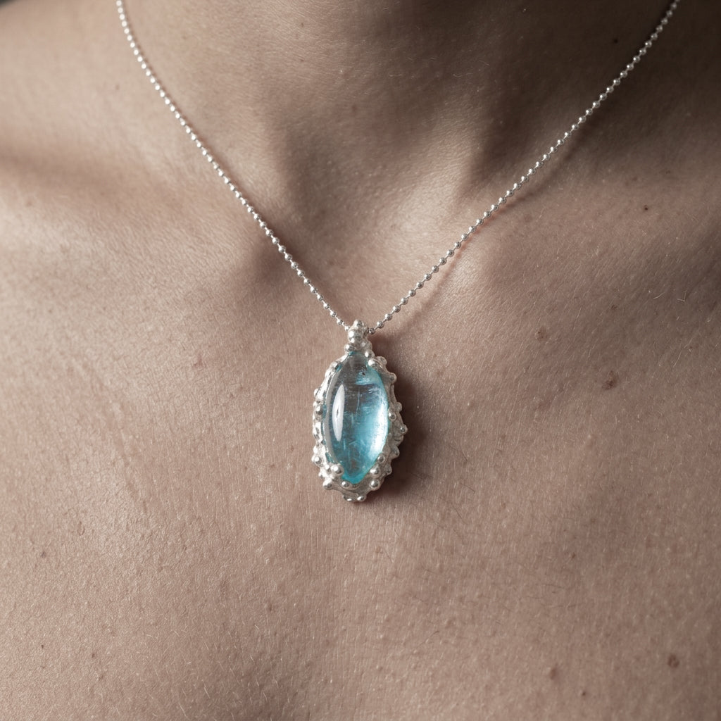 Necklace with a blue pendant on a person's neck